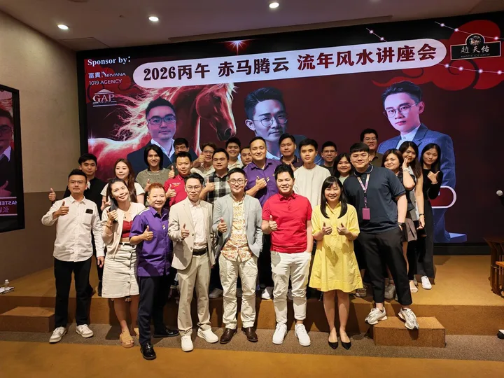 A group posing in front of a stage display at an indoor industry gathering.